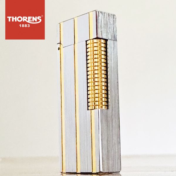 Изысканная газовая зажигалка Thorens в серебряно-золотистом цвете.